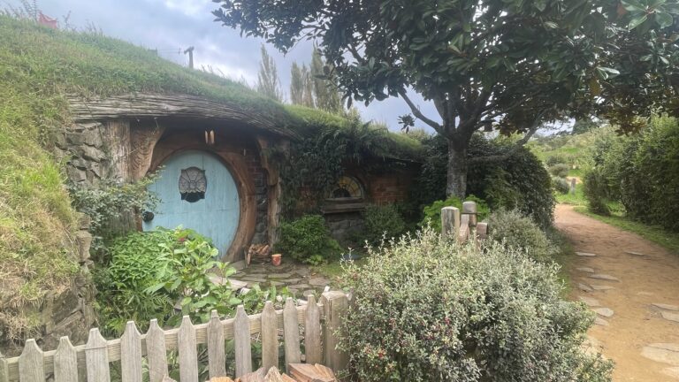 A blue hobbit-hole door in the hillside at Hobbiton