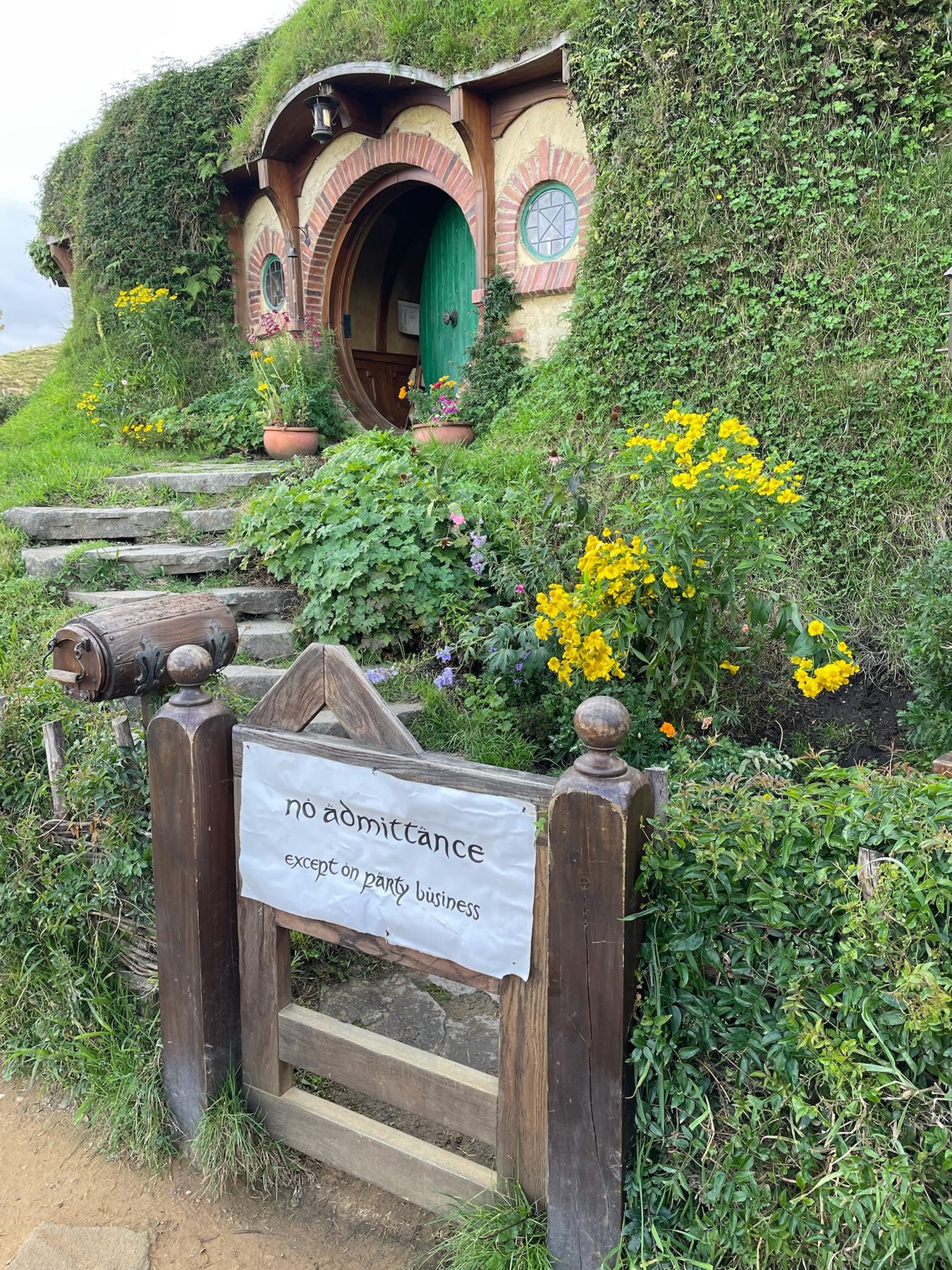 Steps up to a hobbit hole with a "No admittance except on party business" sign